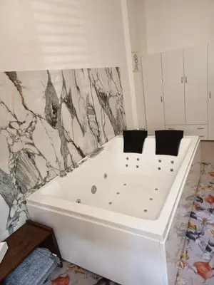 a bath tub in a bathroom with a marble wall at casa colombo in Balestrate