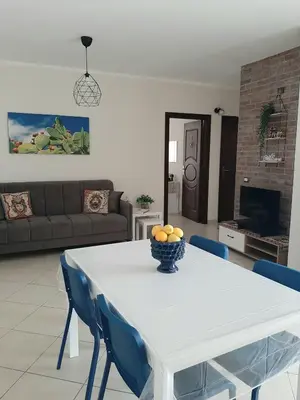a living room with a white table and blue chairs at Stella del Centro Apartment in Palermo