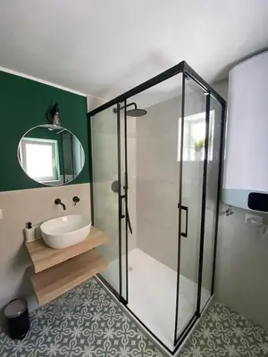 a bathroom with a glass shower and a sink at Calvello studio apartment in Palermo