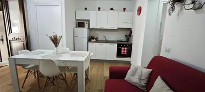 a kitchen with a white table and a red chair at Profumo di casa in Lascari