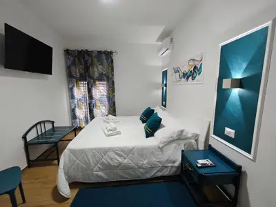 a small bedroom with a bed and a tv at Profumo di casa in Lascari