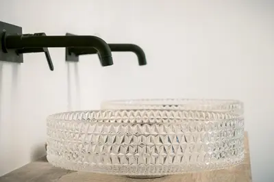 a white basket on a table next to a faucet at Palazzo Santa Ninfa - Luxury Mansion in Palermo
