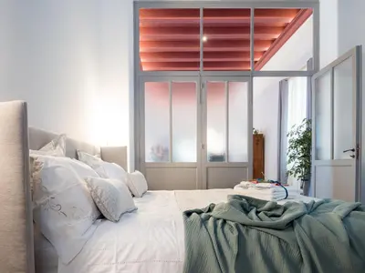 a bedroom with a large bed with a window at Palazzo Santa Ninfa - Luxury Mansion in Palermo