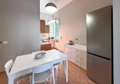 a kitchen with a white table and a refrigerator at Solemar Sicilia - Casa Scordia in Palermo