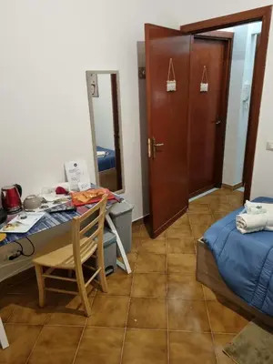 a room with a table and a bed and a door at Le stanze di Aurora in Palermo