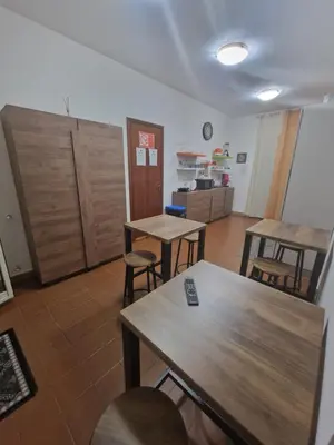 a room with tables and chairs and a kitchen at Le stanze di Aurora in Palermo