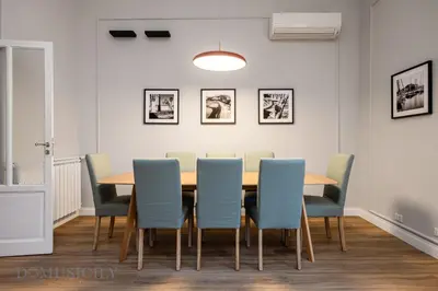 a dining room with a table and blue chairs at Constance Luxury Apartment by DomuSicily in Palermo