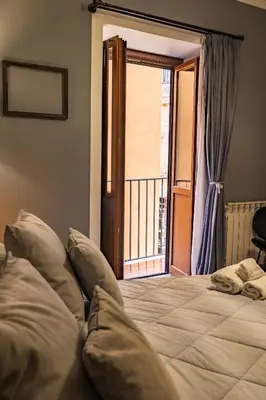 a bedroom with a bed and a door to a balcony at Le radici di Gallidoro in Palermo