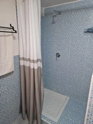 a shower with a shower curtain in a bathroom at Gianni House Palermo in Palermo