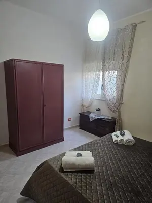 a bedroom with a bed and a cabinet and towels at A casa di Livia in Villabate