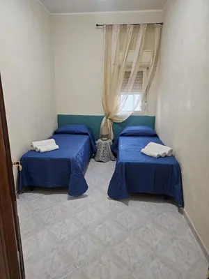 a room with two beds and a window at A casa di Livia in Villabate
