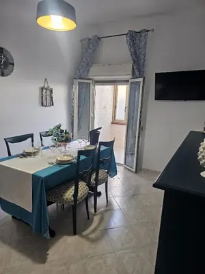 a dining room with a blue table and chairs at A casa di Livia in Villabate
