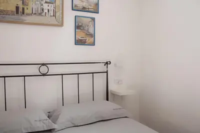 a bedroom with a bed and two pictures on the wall at Leone Guest House in Palermo