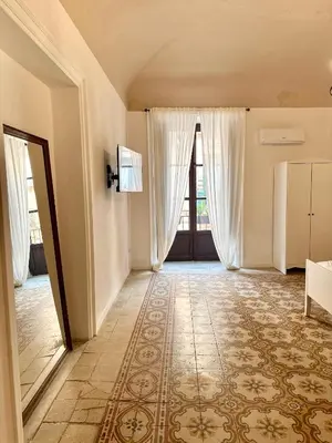 a bedroom with a bed with a painting on the wall at Kalsa Baroque Apartment in Palermo