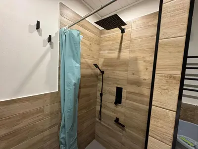 a shower in a bathroom with wooden walls at Sogni d'oro in Partinico