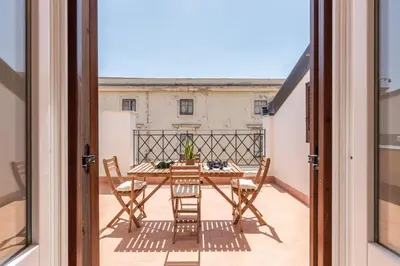 a patio with a table and chairs on a balcony at Oretea Apartment with Terrace by Wonderful Italy in Palermo