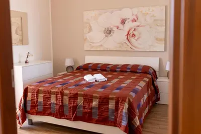 a bedroom with a bed with a plaid blanket at Oltre il Mare Trabia in Trabia