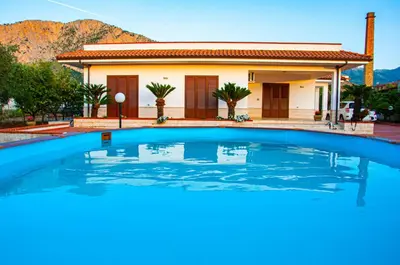 a swimming pool in front of a house at Casa Vacanze Caruso in Carini