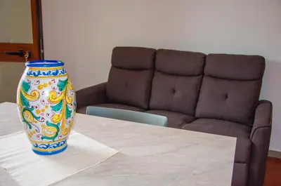 a vase sitting on top of a table with a couch at Casa Vacanze Caruso in Carini