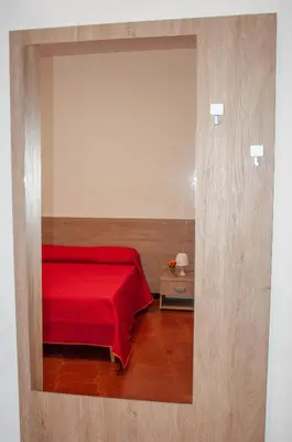 a bedroom with a red bed with a red blanket at Casa Vacanze Caruso in Carini