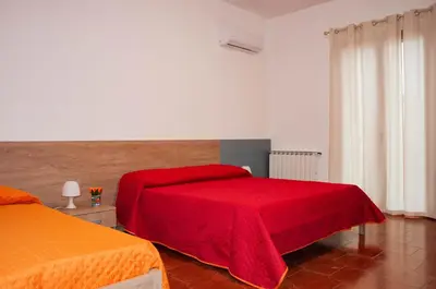 a bedroom with two beds with a red blanket at Casa Vacanze Caruso in Carini