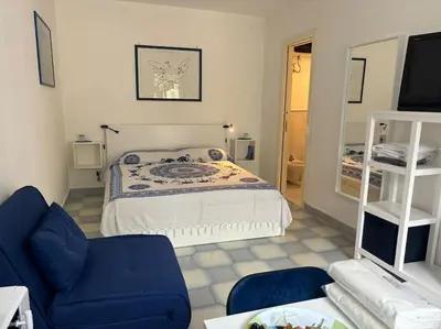 a bedroom with a bed and a couch and a tv at Residenza Saturno 7 in Palermo