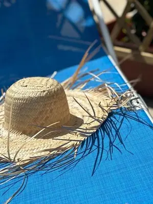 a straw hat sitting on top of a blue table at Residenza Saturno 7 in Palermo