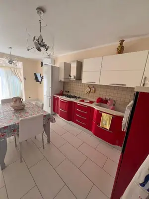 a kitchen with red cabinets and a table in it at Casa delle Stelle in Mondello