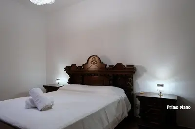 a bedroom with a large bed with a wooden headboard at Appartamenti Esther in San Vito lo Capo
