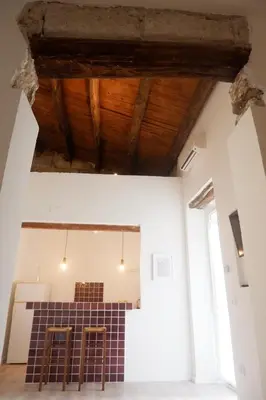 a room with two bar stools and a wooden ceiling at Palazzo Crisafulli 1- casa Liberty con vasca esterna in Palermo