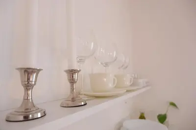 a shelf with wine glasses and plates on it at Palazzo Crisafulli 1- casa Liberty con vasca esterna in Palermo