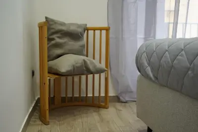 a chair with a pillow on it next to a couch at Il Mio Canto Home in Palermo