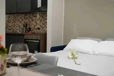 a white bed with a table with a plate and a glass at Il Mio Canto Home in Palermo