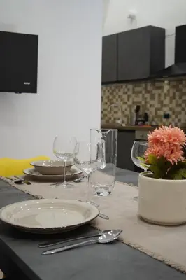 a table with plates and glasses on a kitchen counter at Il Mio Canto Home in Palermo