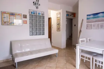 a living room with a white bench and a table at Cefalù, Lascari - Appartamento moderno vicino al mare in Lascari