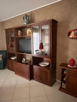 a large wooden entertainment center with a television in it at Anna&Micky town house in Santa Flavia