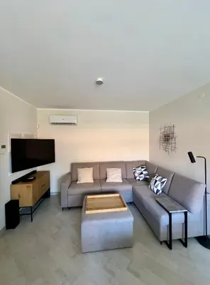 a living room with a couch and a flat screen tv at NOVIMO Comfort Apartment with elevator & secure privat parking in Terrasini