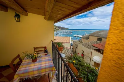 a balcony with a table and a view of the ocean at Le Scalette in Castellammare del Golfo