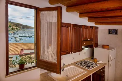a kitchen with a window with a view of the water at Le Scalette in Castellammare del Golfo