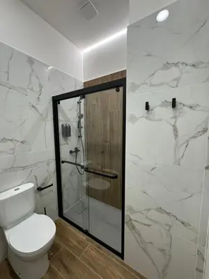 a bathroom with a toilet and a glass shower at Casa Bedda - INTERA CASA CON 3 CAMERE CON BAGNO PRIVATO, ARIA CONDIZIONATA E NO ZTL/ENTIRE APARTMENT WITH 3 BEDROOMS WITH PRIVATE BATHROOM, AIRCON AND NO LTZ in Castellammare del Golfo