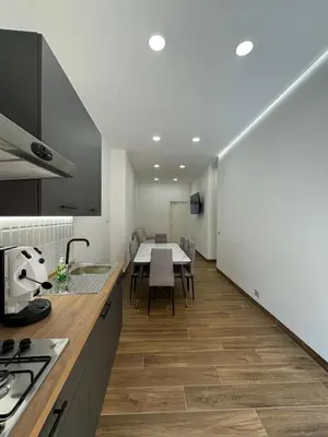 a kitchen with a table and a dining room at Casa Bedda - INTERA CASA CON 3 CAMERE CON BAGNO PRIVATO, ARIA CONDIZIONATA E NO ZTL/ENTIRE APARTMENT WITH 3 BEDROOMS WITH PRIVATE BATHROOM, AIRCON AND NO LTZ in Castellammare del Golfo