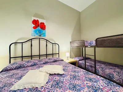 a bedroom with two beds and a painting of flowers at Angelia in Capaci