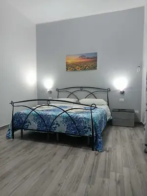 a bedroom with a bed and a wooden floor at Il Tramonto - BALESTRATE in Balestrate
