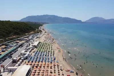 a beach with many umbrellas and people in the water at Il Tramonto - BALESTRATE in Balestrate