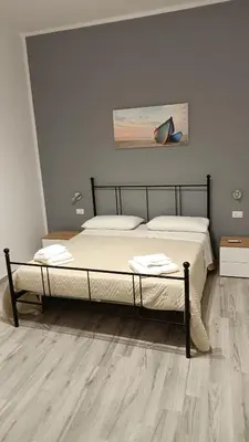 a large bed in a bedroom with a wooden floor at Il Tramonto - BALESTRATE in Balestrate