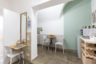 a kitchen with a table and chairs in a room at appartamento centro storico - La casuzza alla Cala in Palermo