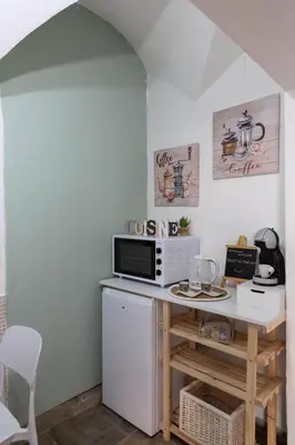 a small kitchen with a microwave and a table at appartamento centro storico - La casuzza alla Cala in Palermo
