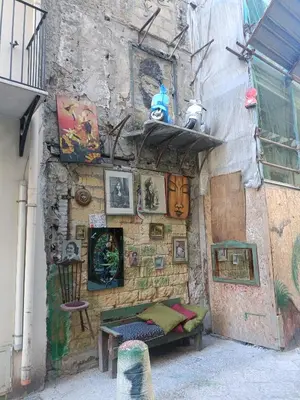 a wall with a bench and paintings on it at appartamento centro storico - La casuzza alla Cala in Palermo