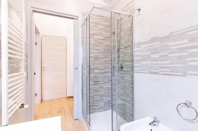 a bathroom with a glass shower and a sink at Stabile 38 Apartments in Palermo