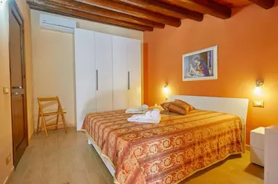 a bedroom with a bed in a room with orange walls at Casa Maria Stella Scopello in Scopello